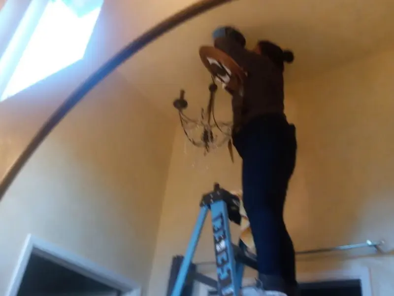 Electrician installing a chandelier in a Fair Oaks residence